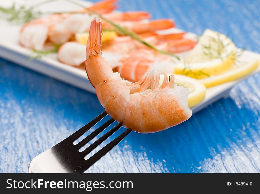 Photo of delicious raw prawns with lemon slices and onions on white plate. Photo of delicious raw prawns with lemon slices and onions on white plate