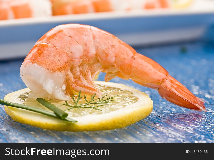 Photo of delicious raw prawns with lemon slices and onions on white plate. Photo of delicious raw prawns with lemon slices and onions on white plate