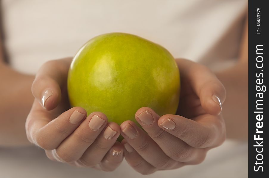 Fresh green apple in a woman hand close up