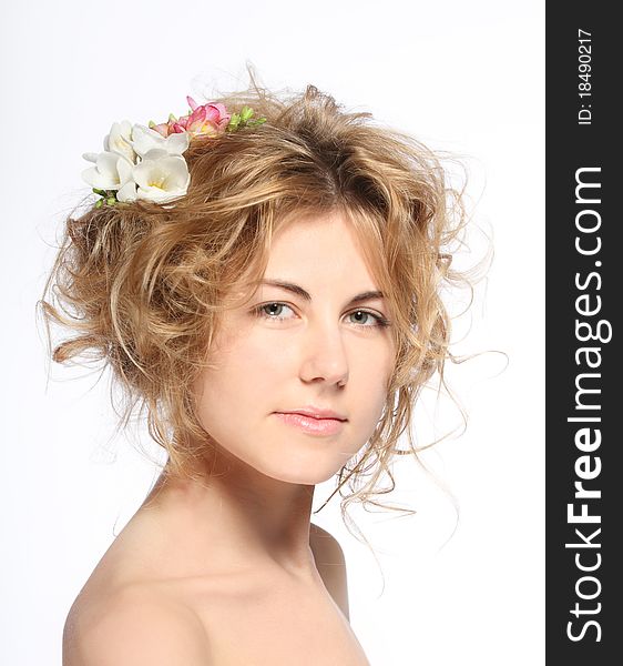 Portrait of the beauty young blond girl with freesia in her hair