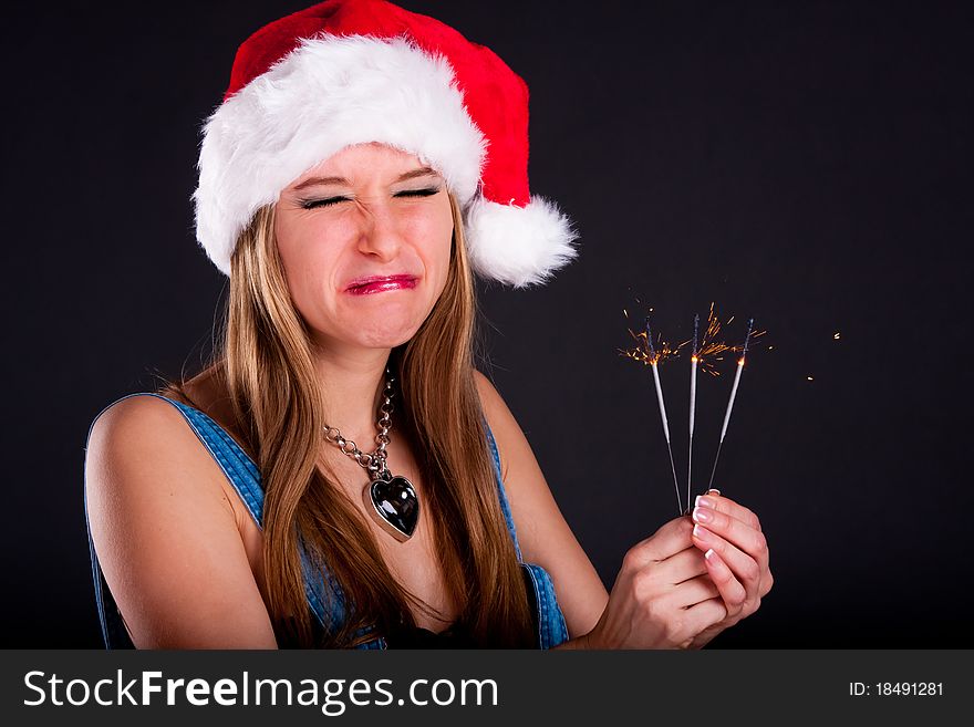 Cute girl in Santa hat holding sparklers. Cute girl in Santa hat holding sparklers