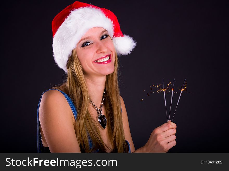 Cute girl in Santa hat holding sparklers. Cute girl in Santa hat holding sparklers