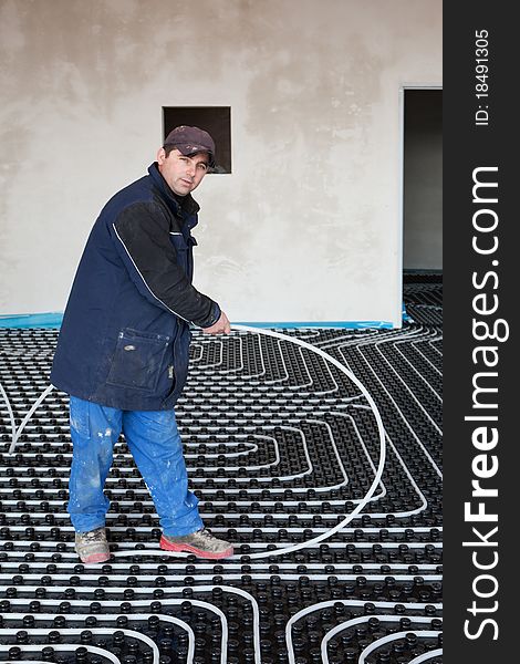 Underfloor heating and cooling, man work on building site