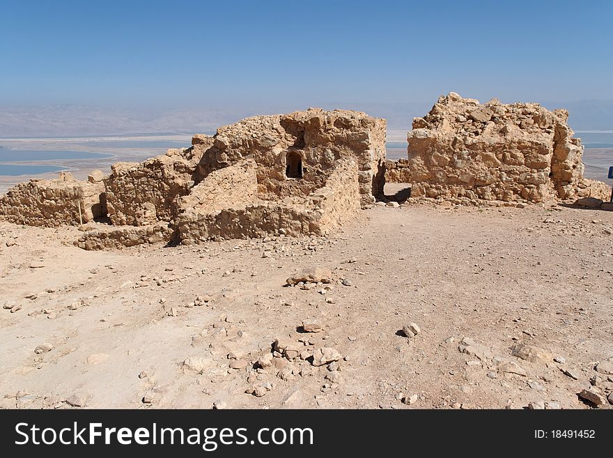 Ruins of ancient Masada fortress on Dead Sea background