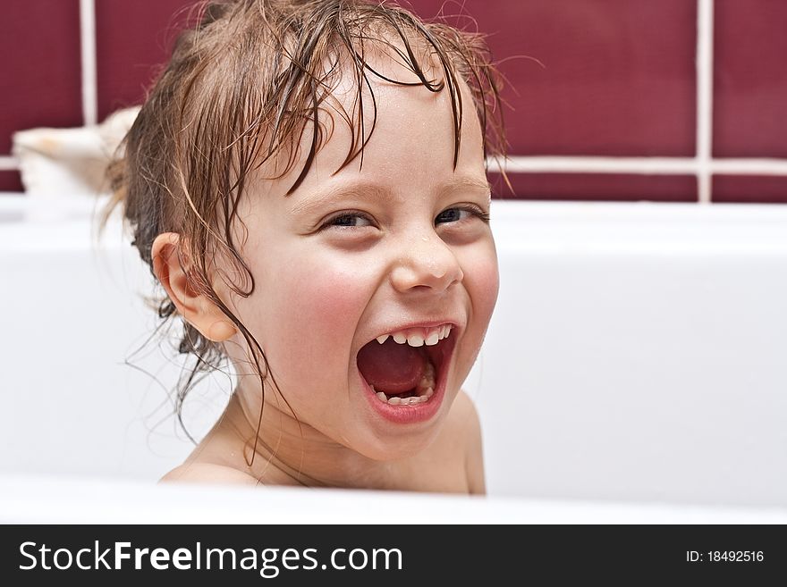 Girl looking out of a bath and smiling