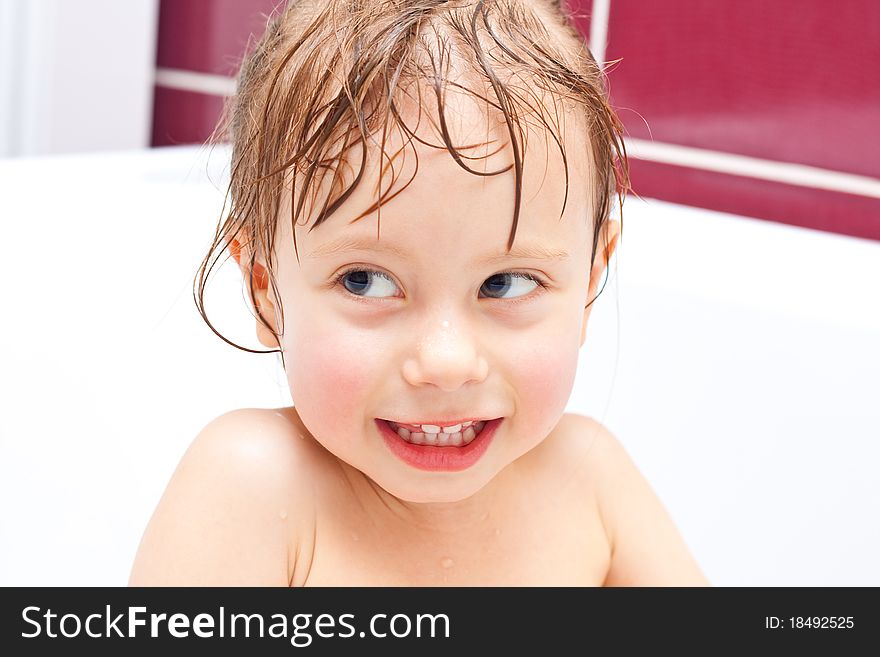 Girl looking out of a bath and smiling