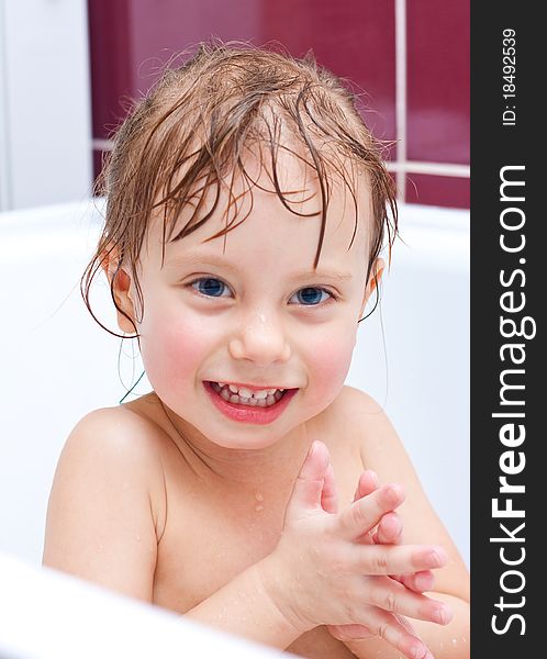 Girl looking out of a bath and smiling