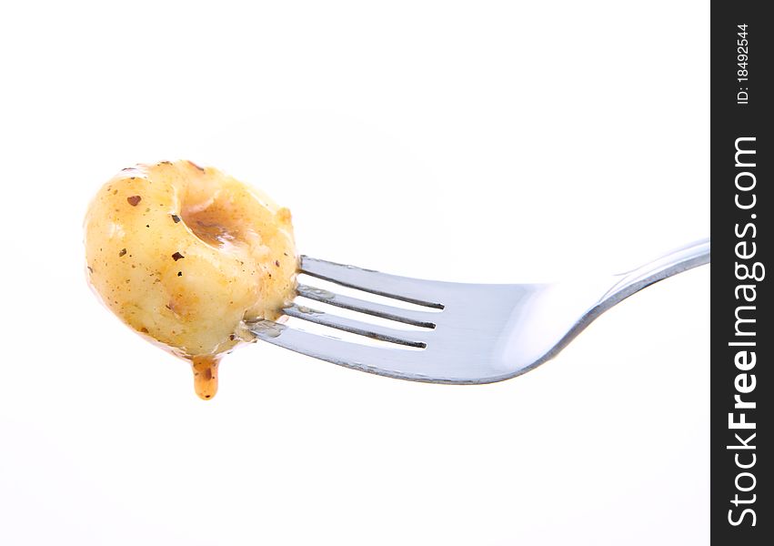 Dumpling covered with sauce on a fork on a white background. Dumpling covered with sauce on a fork on a white background