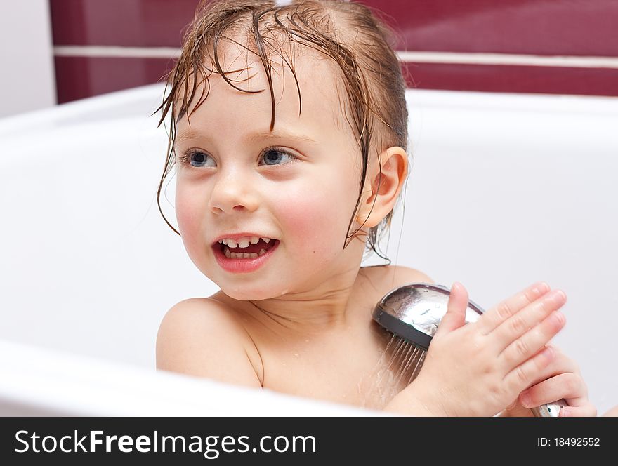 Girl looking out of a bath and smiling