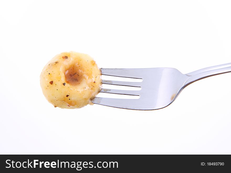 Dumpling covered with sauce on a fork on a white background. Dumpling covered with sauce on a fork on a white background