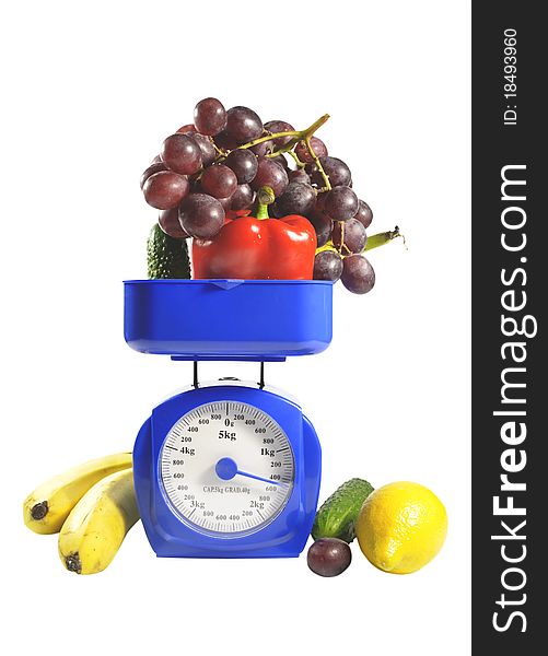 Fruit and vegetables on scales. It is isolated on a white background