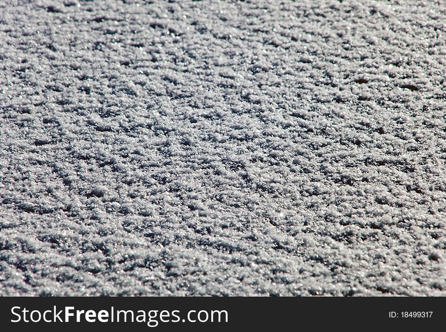 Snow on flat surface on sunny day.