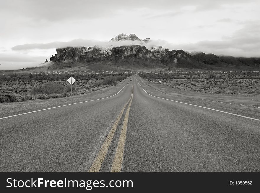 Lonely road on a stormy winter day leading to the Superstition Mountains in Arizona. Lonely road on a stormy winter day leading to the Superstition Mountains in Arizona