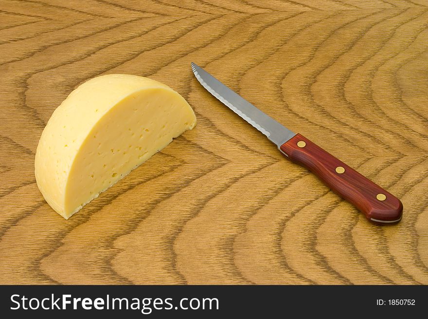 Cheese and knife on wooden table