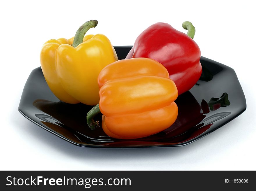 Colorful display of bell peppers on a black plate.