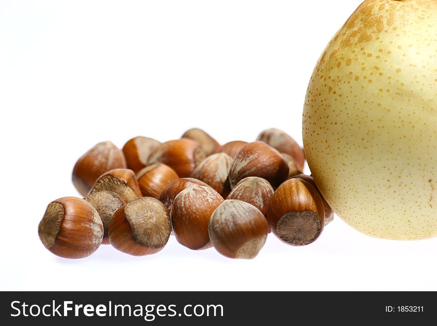 Hazelnuts and pear isolated on white background