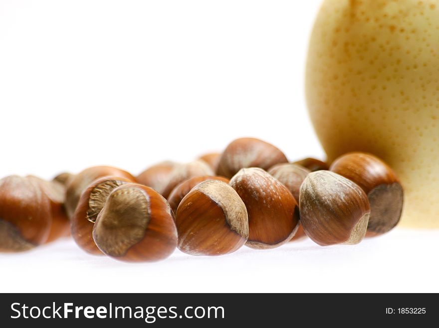 Hazelnuts and pear isolated on white background