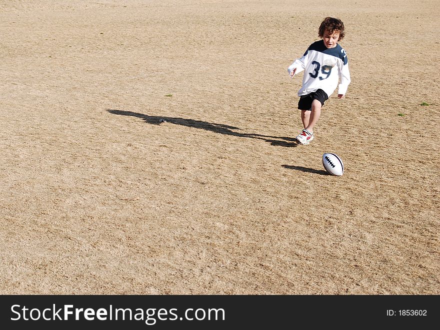 Boy chasing a foot ball. Boy chasing a foot ball