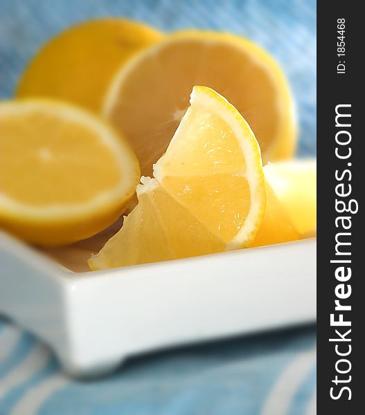 Fresh lemon slices in kitchen sunlight with blue tablecloth