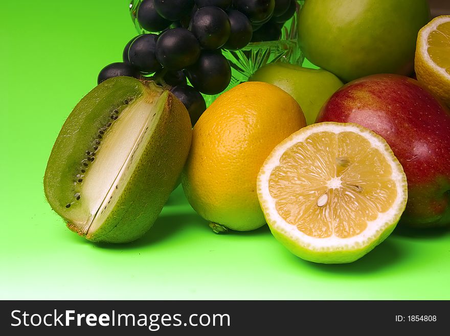 Great number of bright and juicy fruit on a green background