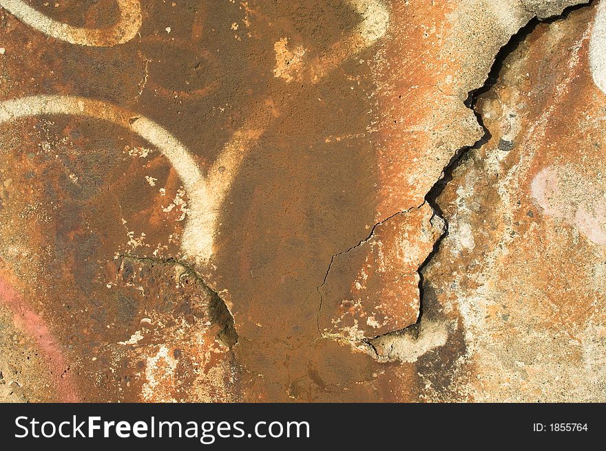 Rusty concrete texture with cracks and graffiti