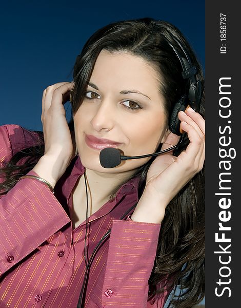 Smiling young woman of a call center, on blue background