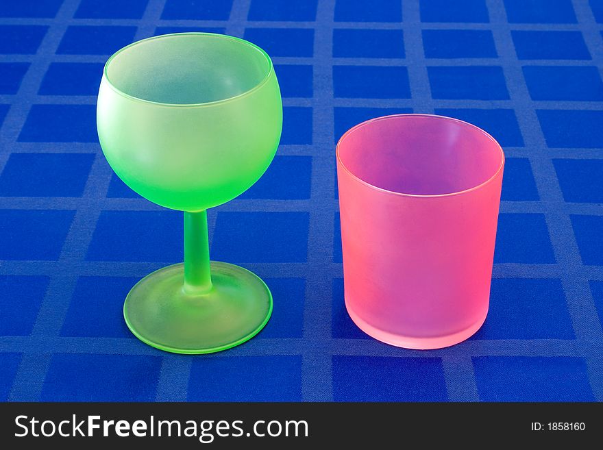 Stylish green and red glass on blue tablecloth
