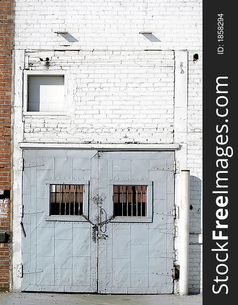 Old warehouse doors with chain and lock and wall. Old warehouse doors with chain and lock and wall