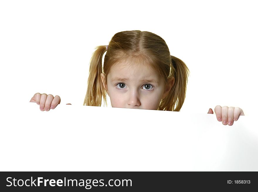 Little girl looking over the edge of a white sign she is holding