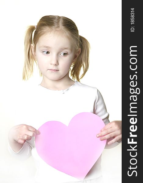 Little girl dressed in white holding a valentine heart. Little girl dressed in white holding a valentine heart