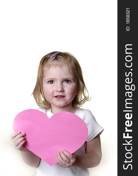 Little girl dressed in white holding a valentine heart. Little girl dressed in white holding a valentine heart