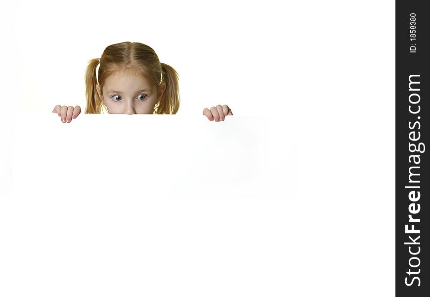 Little girl looking over the edge of a white sign she is holding