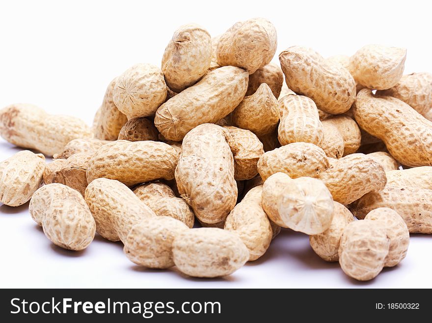 Raw peanuts with skin on a white background