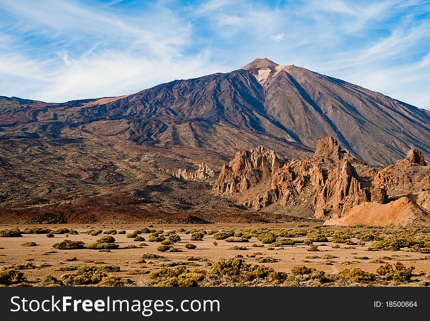 A view of El Teide behind some hugh rocks.