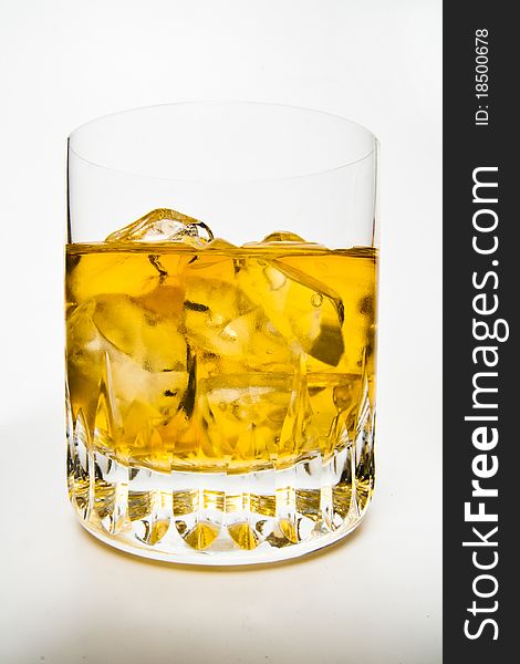 Closed-up of whiskey and ices in a glass with white isolated background.