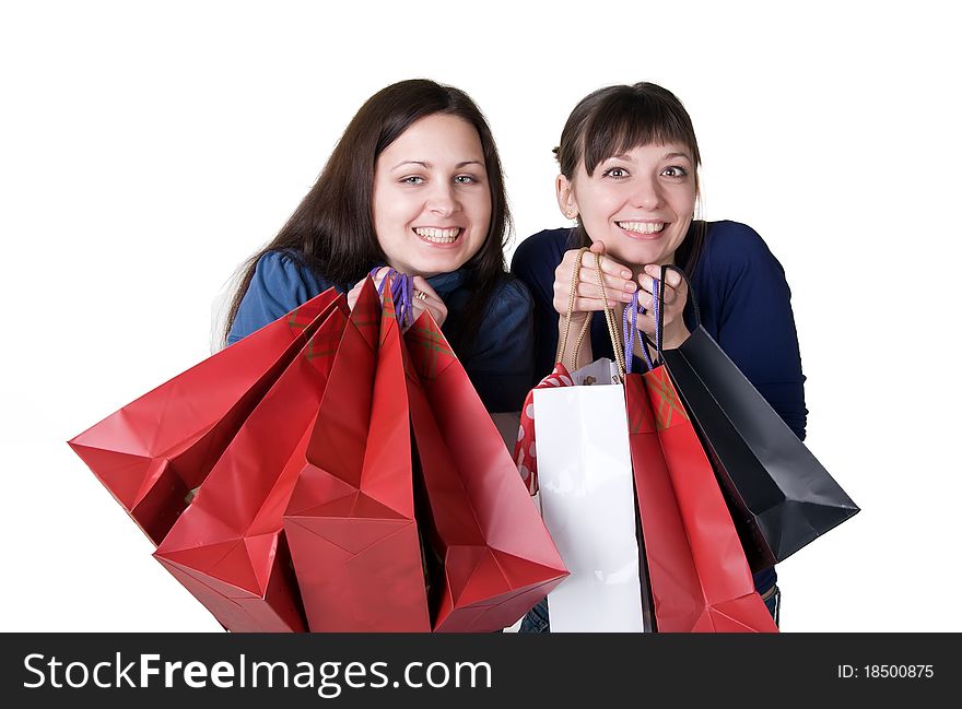 Two happy girls with shopping bags on a white background. Two happy girls with shopping bags on a white background