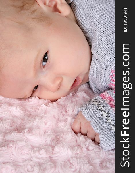 Beautiful baby girl on a pink blanket