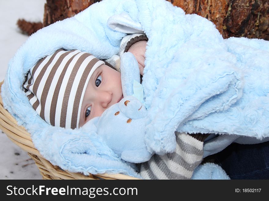 Cute baby boy lying outside in a basket. Cute baby boy lying outside in a basket
