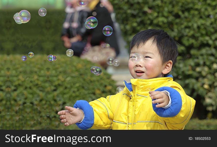 A baby is playing soap bubbles. A baby is playing soap bubbles