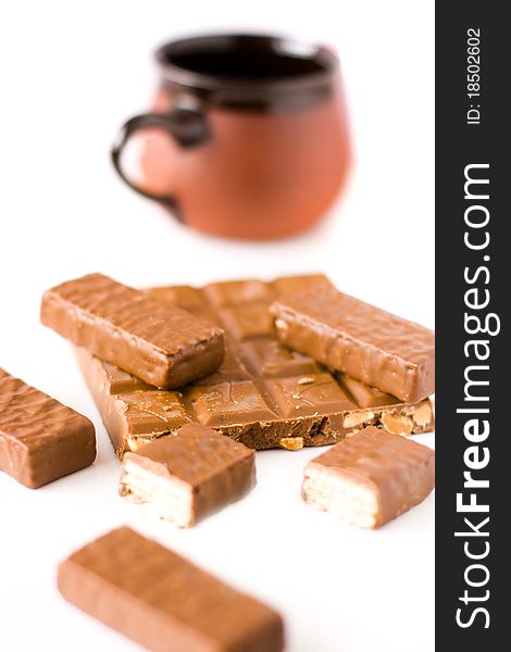 Chocolate bar and chocolate wafers with pot on white background
