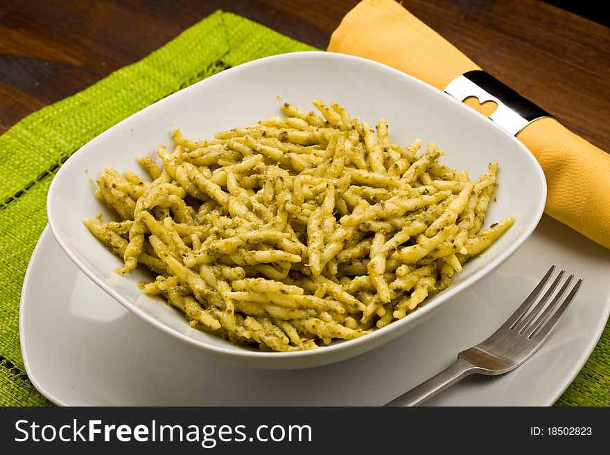 Photo of italian pasta with basil sauce called pesto. Photo of italian pasta with basil sauce called pesto