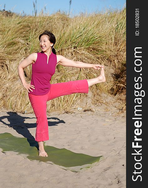 A young woman performs yoga on a beach. A young woman performs yoga on a beach.
