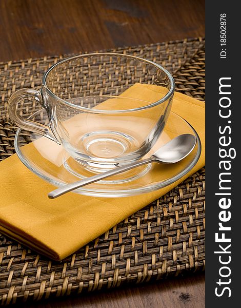 Photo of empty tea cup made of glass on yellow cloth