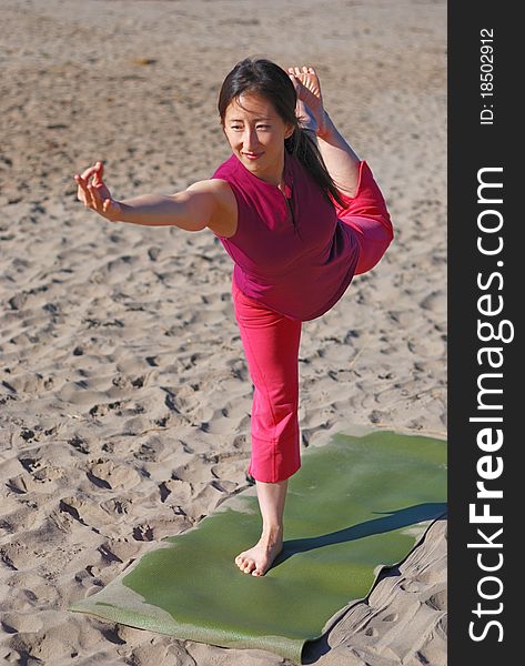 A young woman performs yoga on a beach. A young woman performs yoga on a beach.