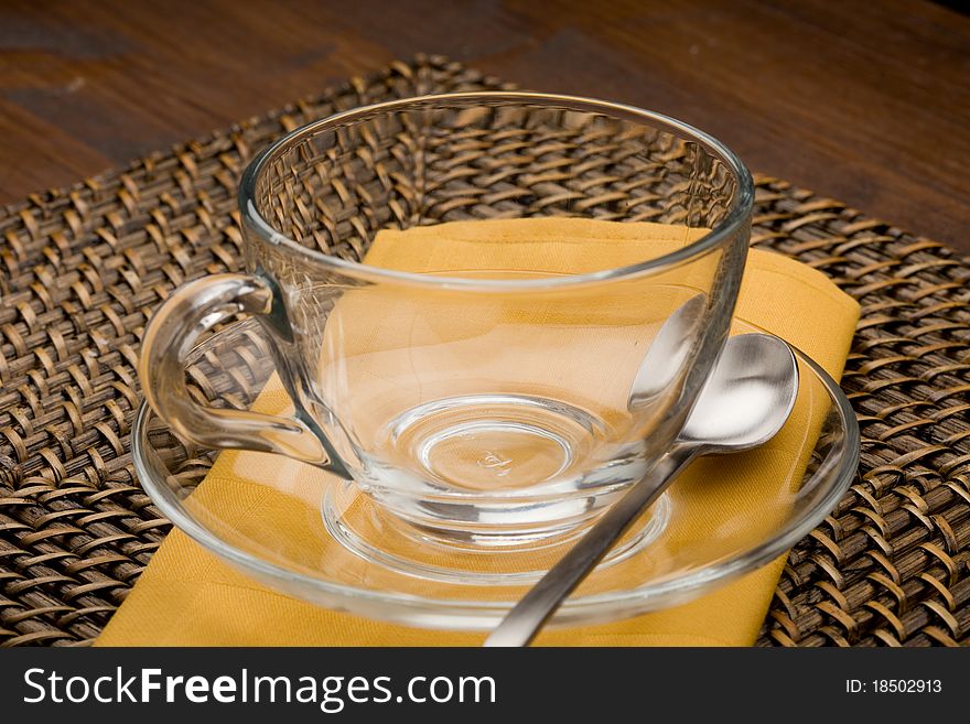 Photo of empty tea cup made of glass on yellow cloth