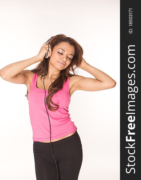 Young woman in pink listening music on white background. Young woman in pink listening music on white background