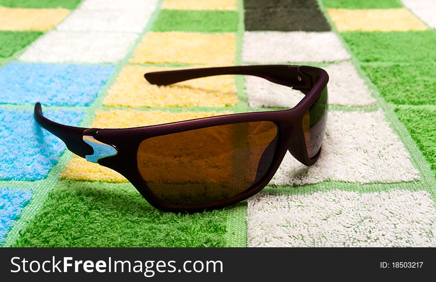 Closeup of sunglasses on a multi-coloured towel