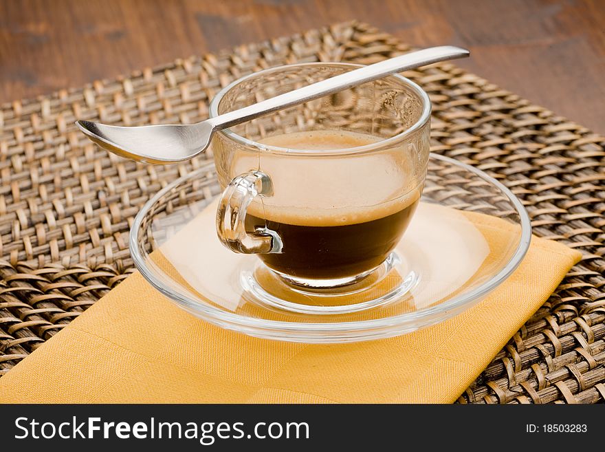 Photo of hot espresso coffee in glass cup with tea spoon