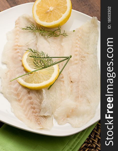 Photo of tasty smoked sea bass fish with lemon slices and fennel on it. Photo of tasty smoked sea bass fish with lemon slices and fennel on it