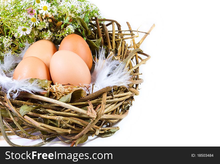 Four fresh eggs in a handmade bird's nest, decorated with flowers.